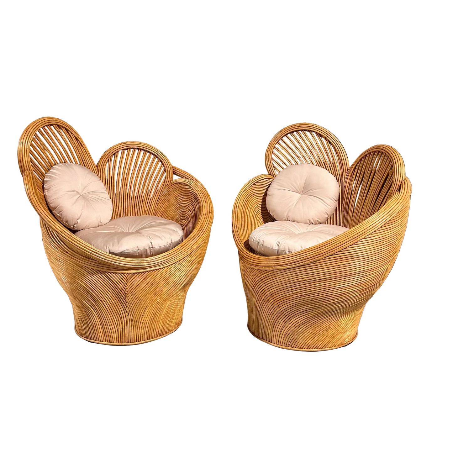 Two wicker chairs with cushions against a white background.