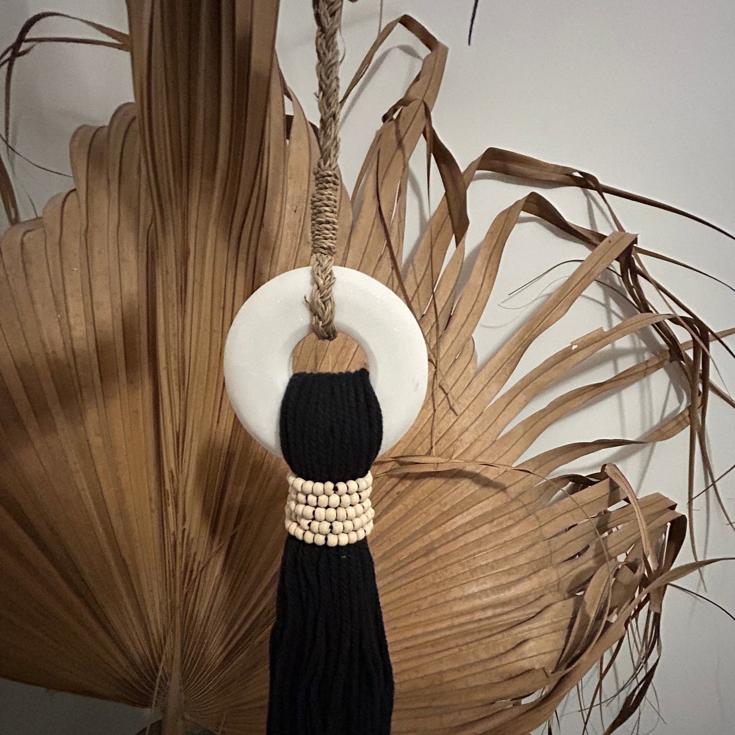 Black cotton and white marble tassel on a neutral background