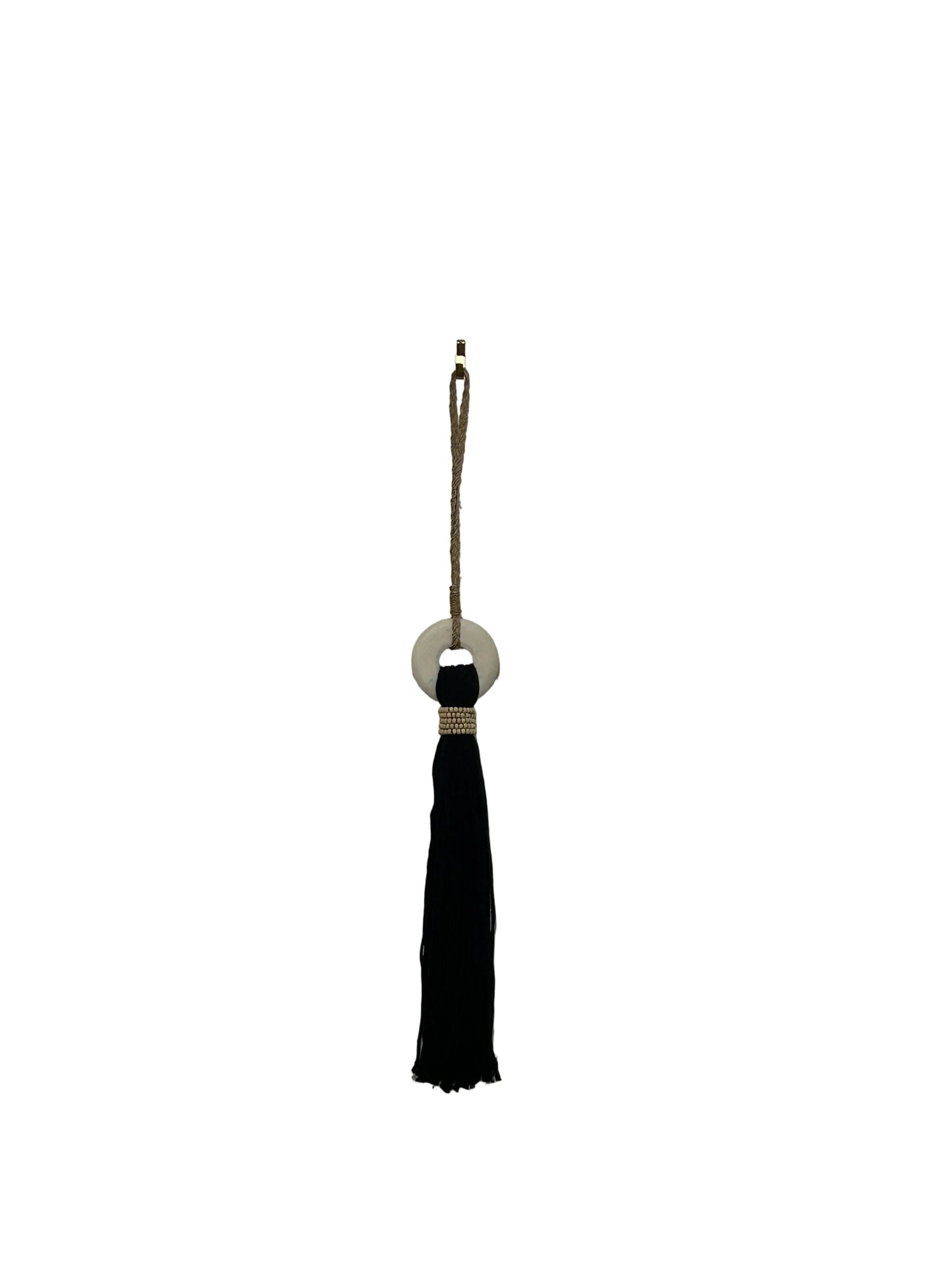 Black cotton and white marble tassel hanging from a string on a plain white background