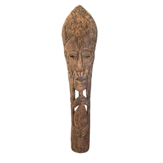 A tall, slender hand-carved coconut wood totem with a distinctive fibrous grain and a tribal-inspired face.