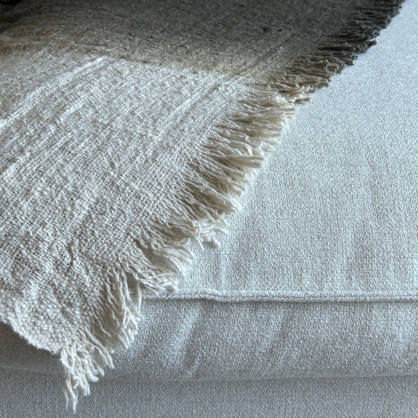 Textured image of throw laid flat showing the graduation of colour from neutral to espresso.