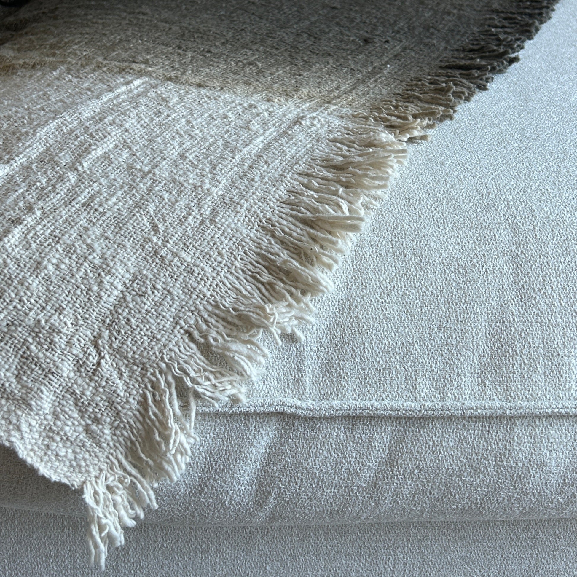 Textured image of throw laid flat showing the graduation of colour from neutral to espresso.
