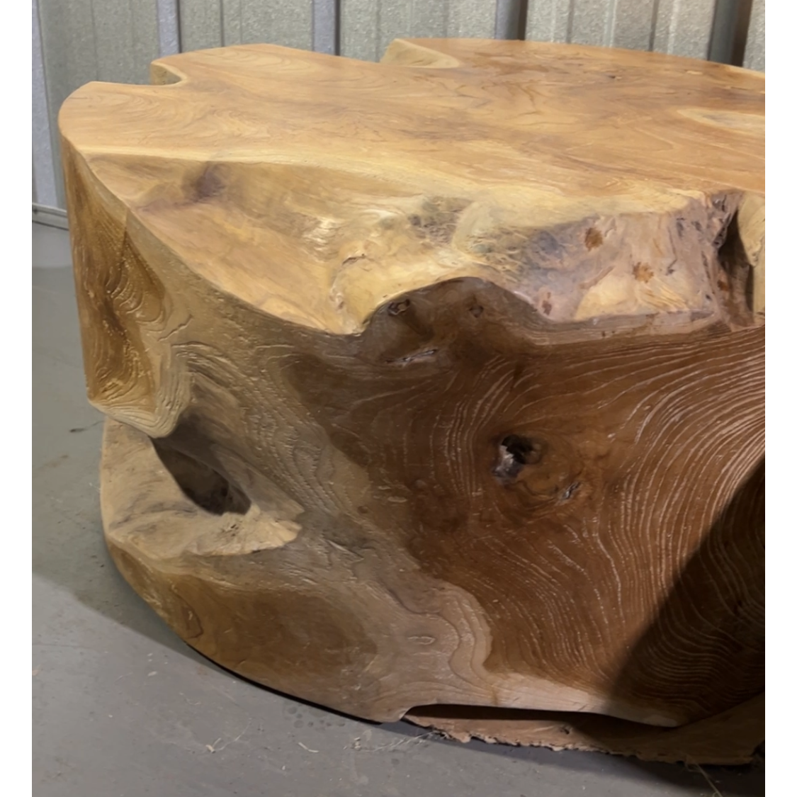 Wooden coffee table with a natural, rustic finish on a gray floor.