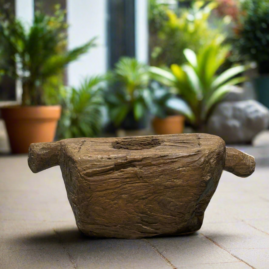 An authentic Indonesian teak wood grinder that features natural imperfections, grain patterns, and a soulful and rustic patina that speaks to its history. 