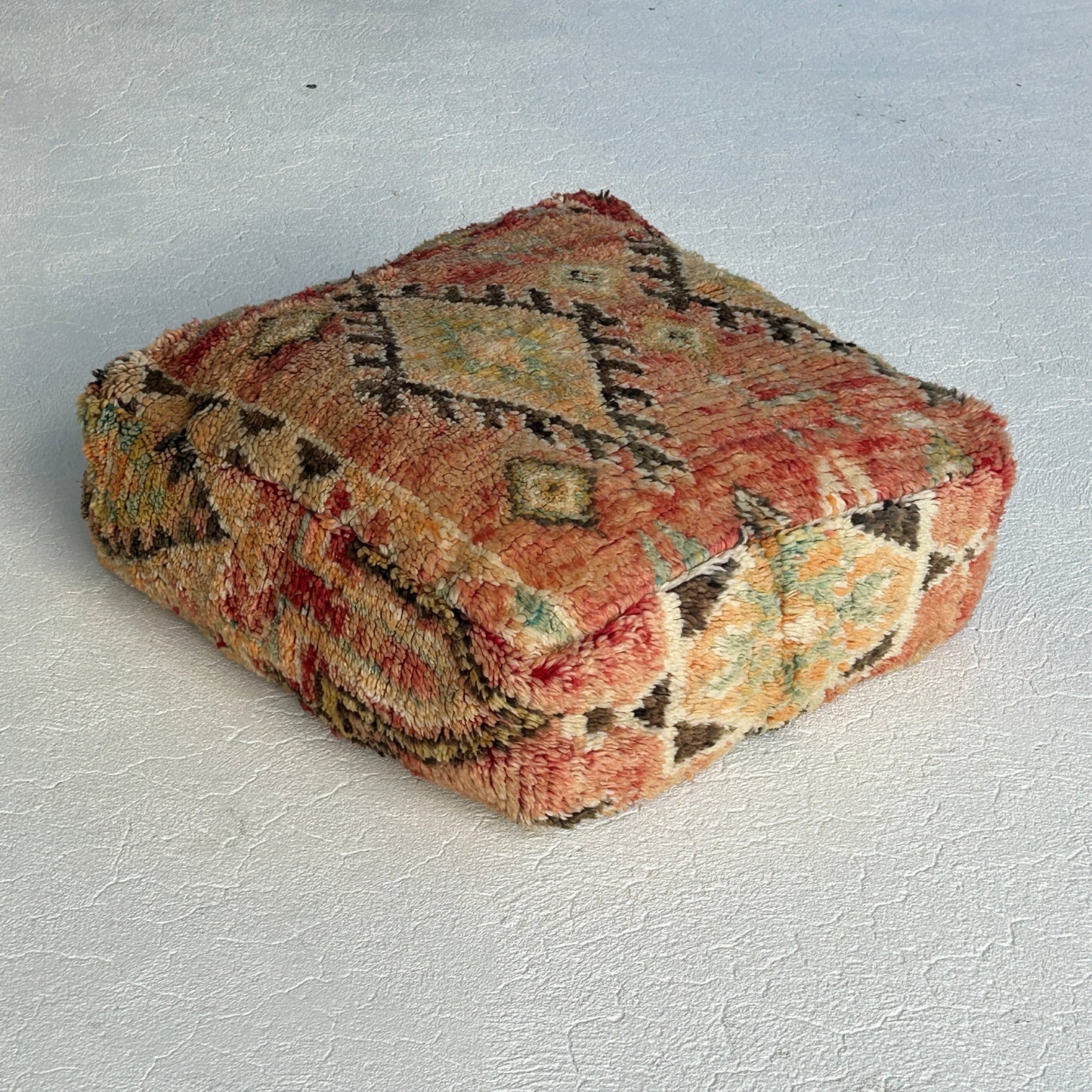 Side view of the Kasbah vintage Moroccan floor cushion featuring terracotta, sage and sand tones with traditional tribal motifs, handcrafted and sourced from Morocco.