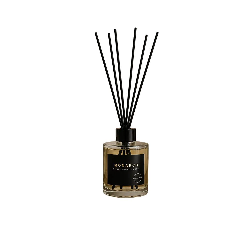 Reed diffuser with black sticks and a clear bottle on a white background