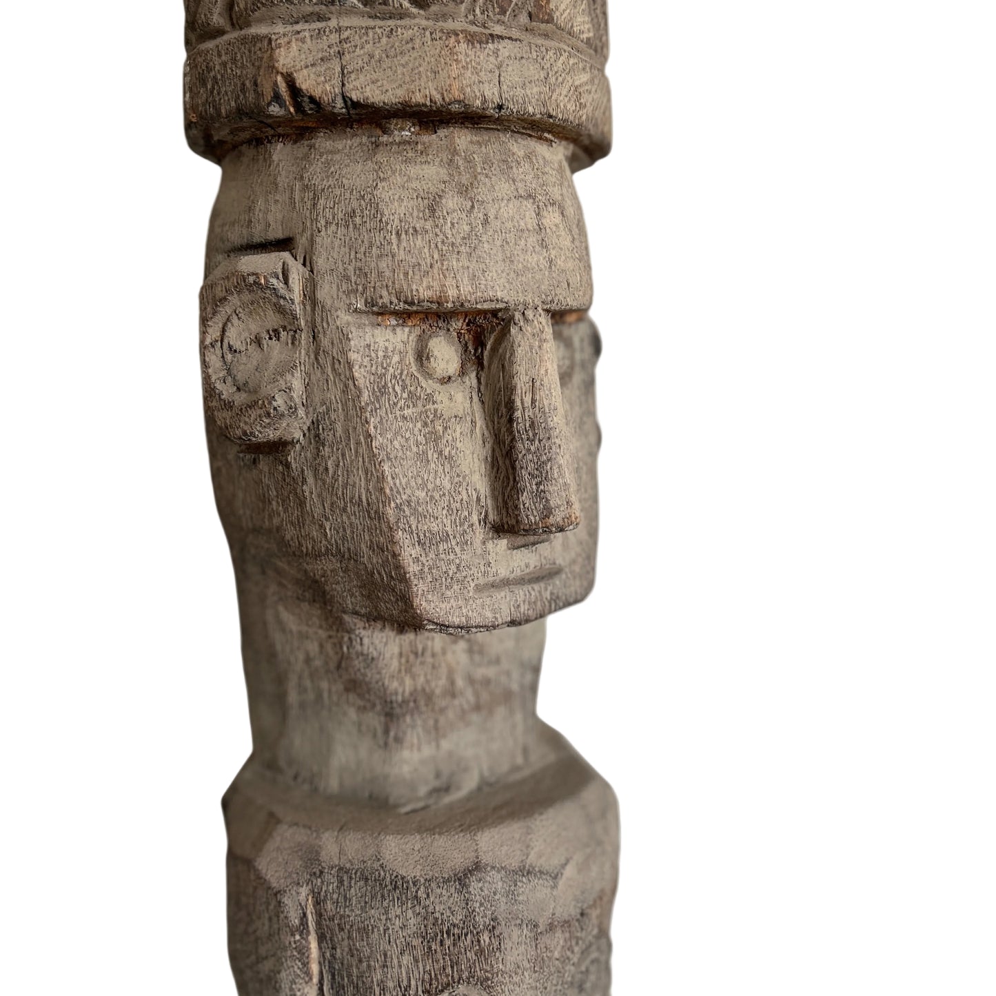 Close up of a wooden Timor totem statue on a 45 degree angle with intricate carvings on a plain background.