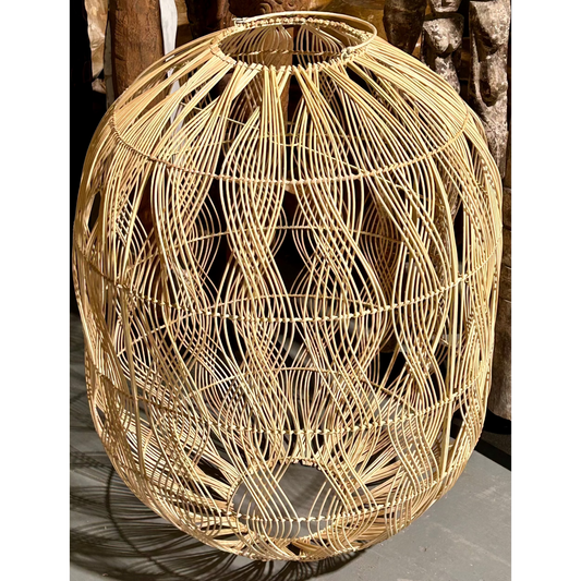 Woven rattan pendant with a vertical wave pattern on a concrete floor.