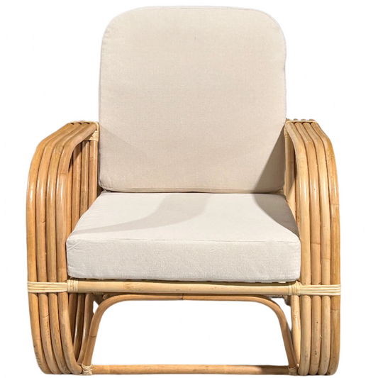 A rattan Slingback Chair with a cushion, showcasing a brown rattan frame and a beige cushion.