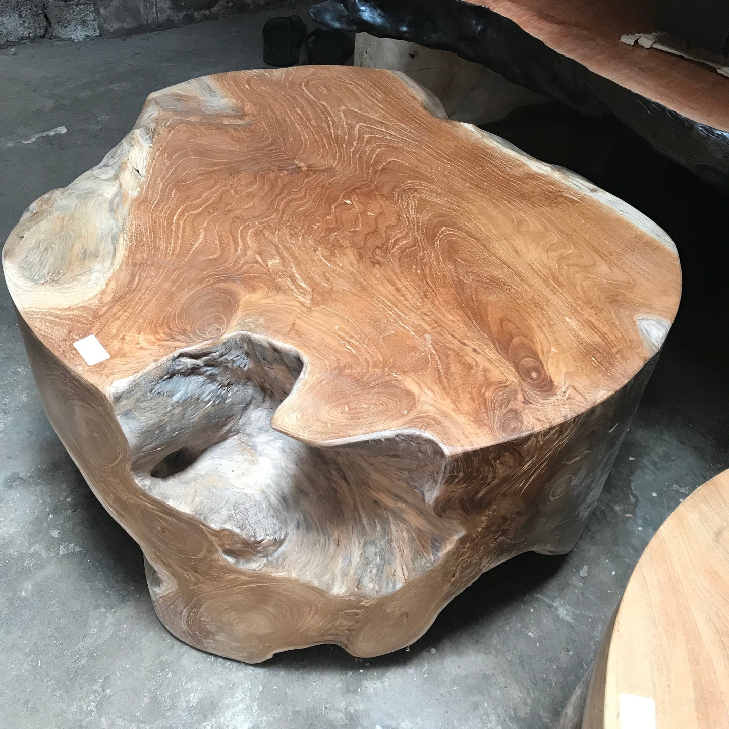 Teak timber coffee table side view displaying honey tones and organic shape.