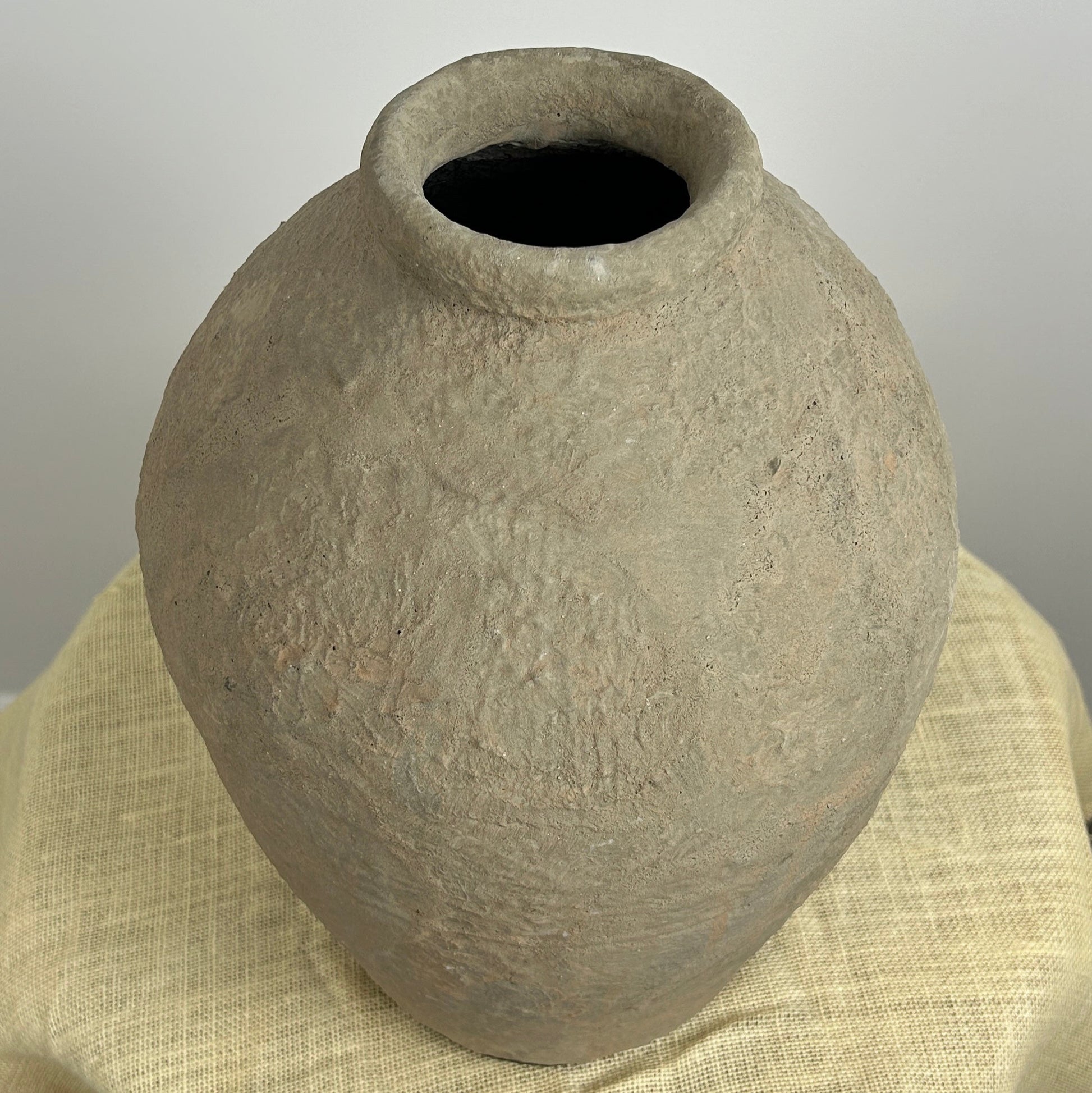 Textured stone look pot on a neutral background.
