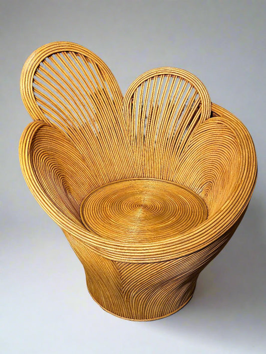 Woven rattan single chair in the shape of flower petals shown against a plain grey background