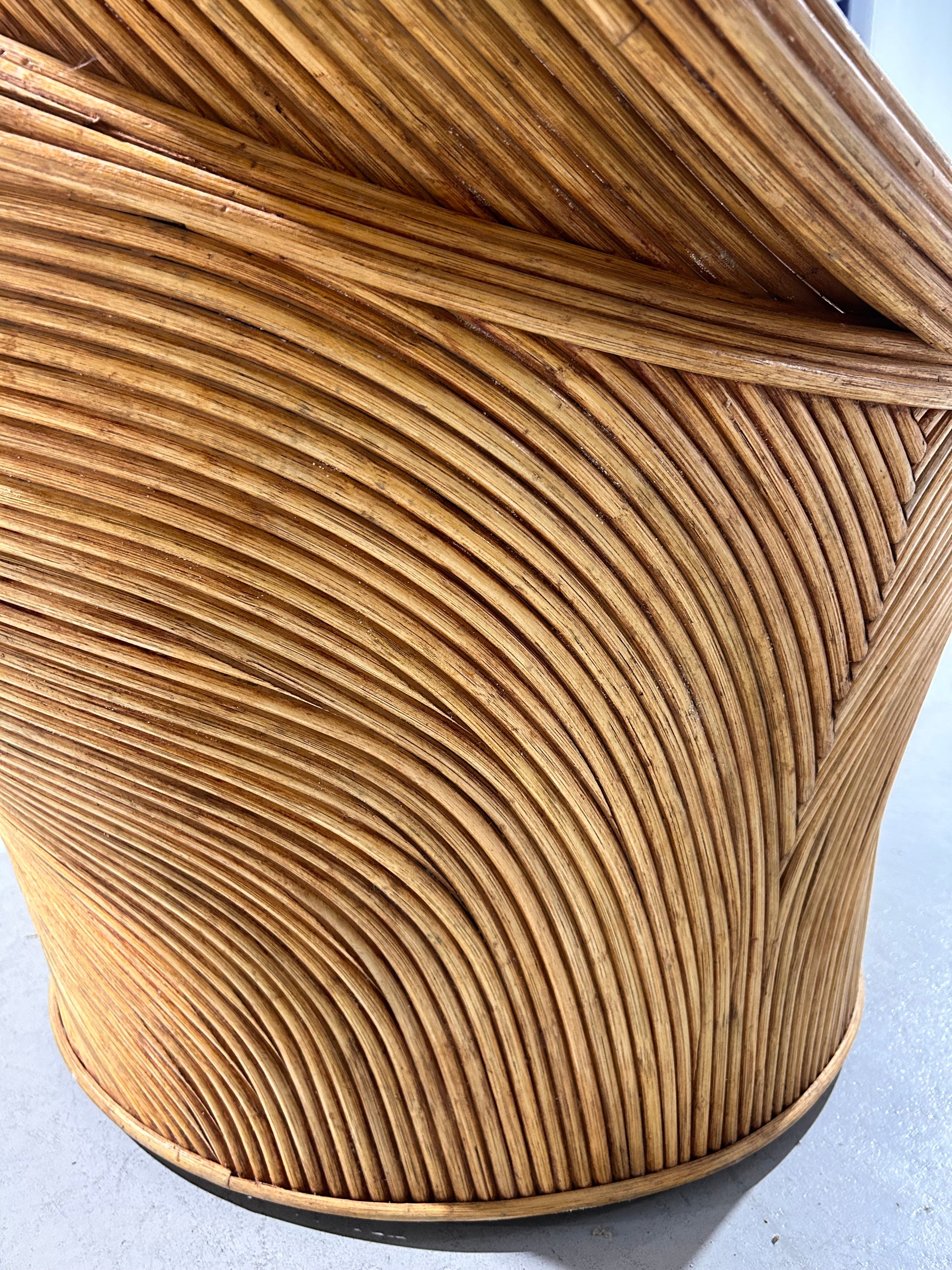 Side profile image of a circular woven rattan chair.
