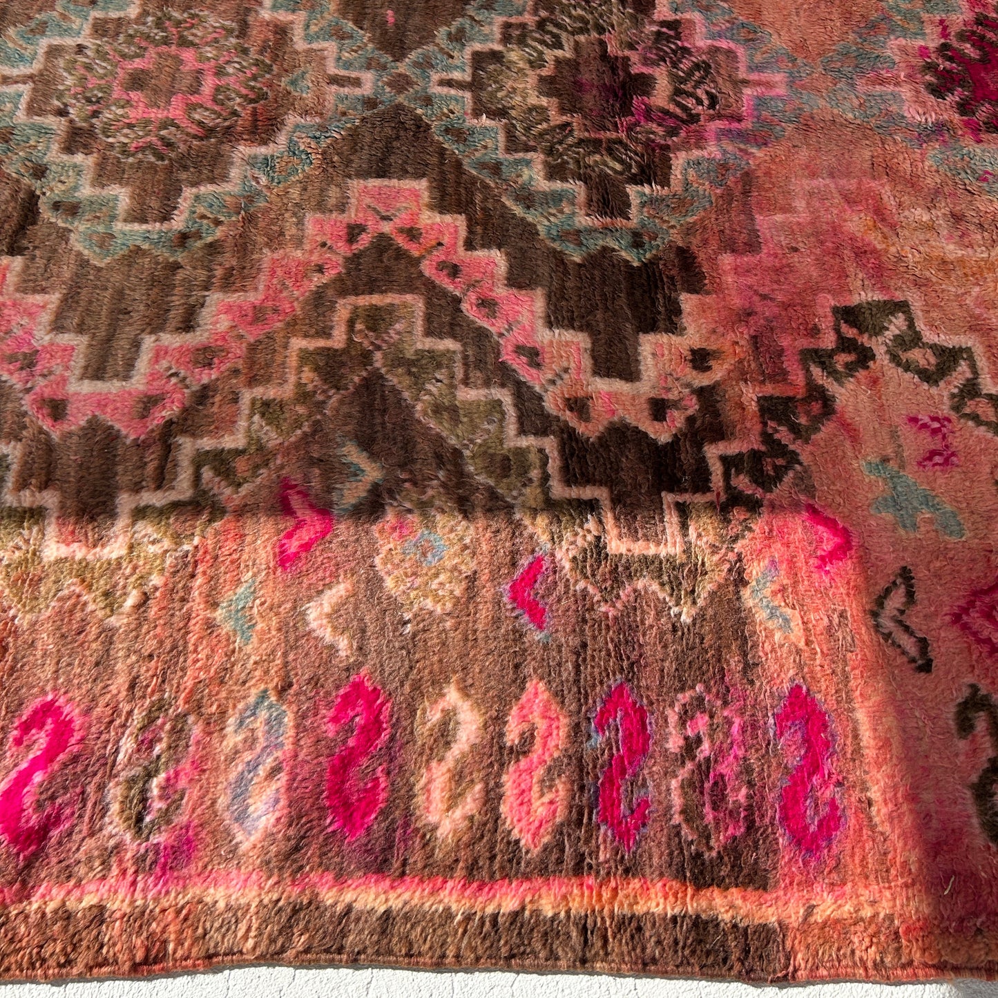 Traditional patterned boujaad Moroccan rug with pink and brown colours, showing border pattern