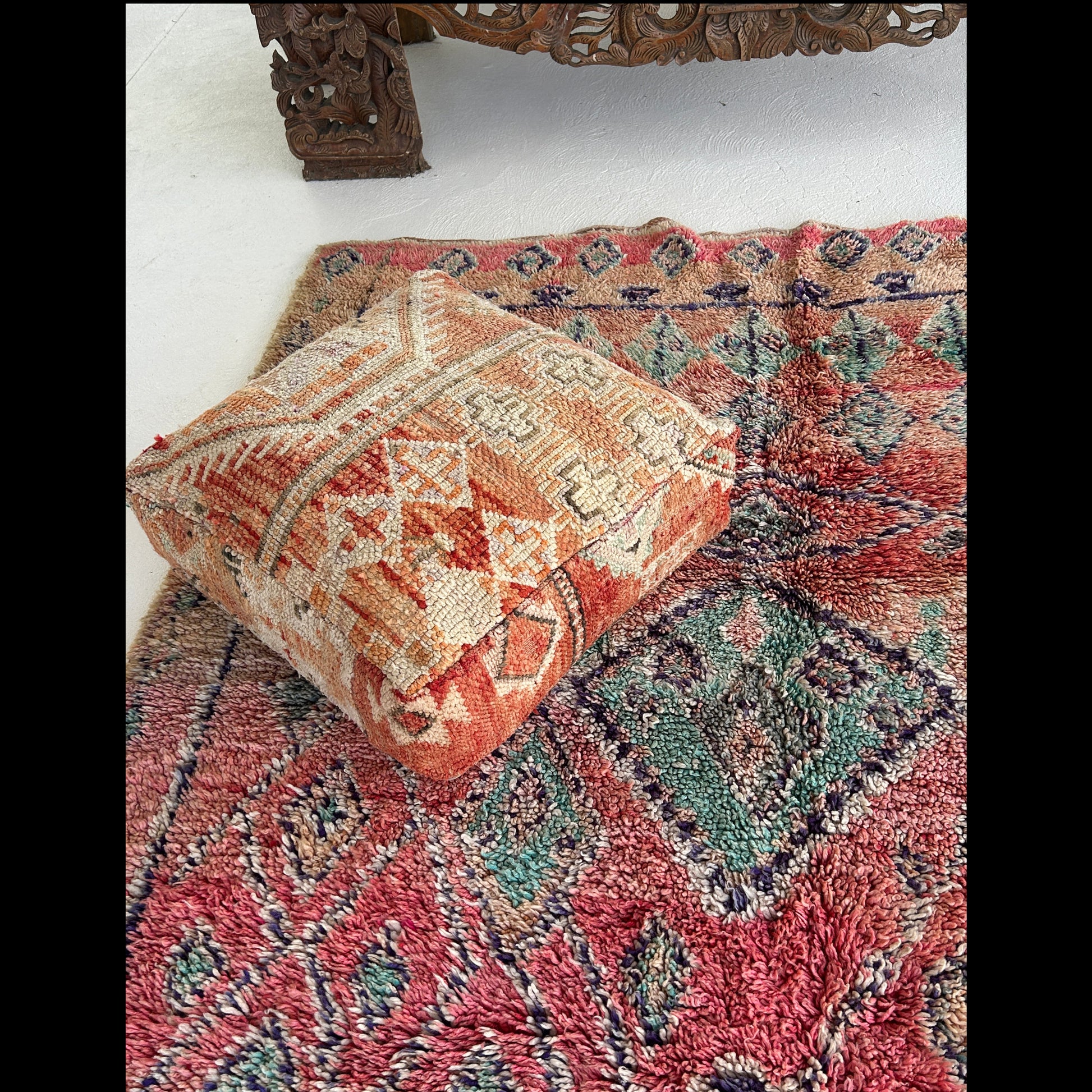 Vintage Moroccan Boujaad Rug raspberry red corner close up of the  background with soft turquoise diamonds and navy border detail.
