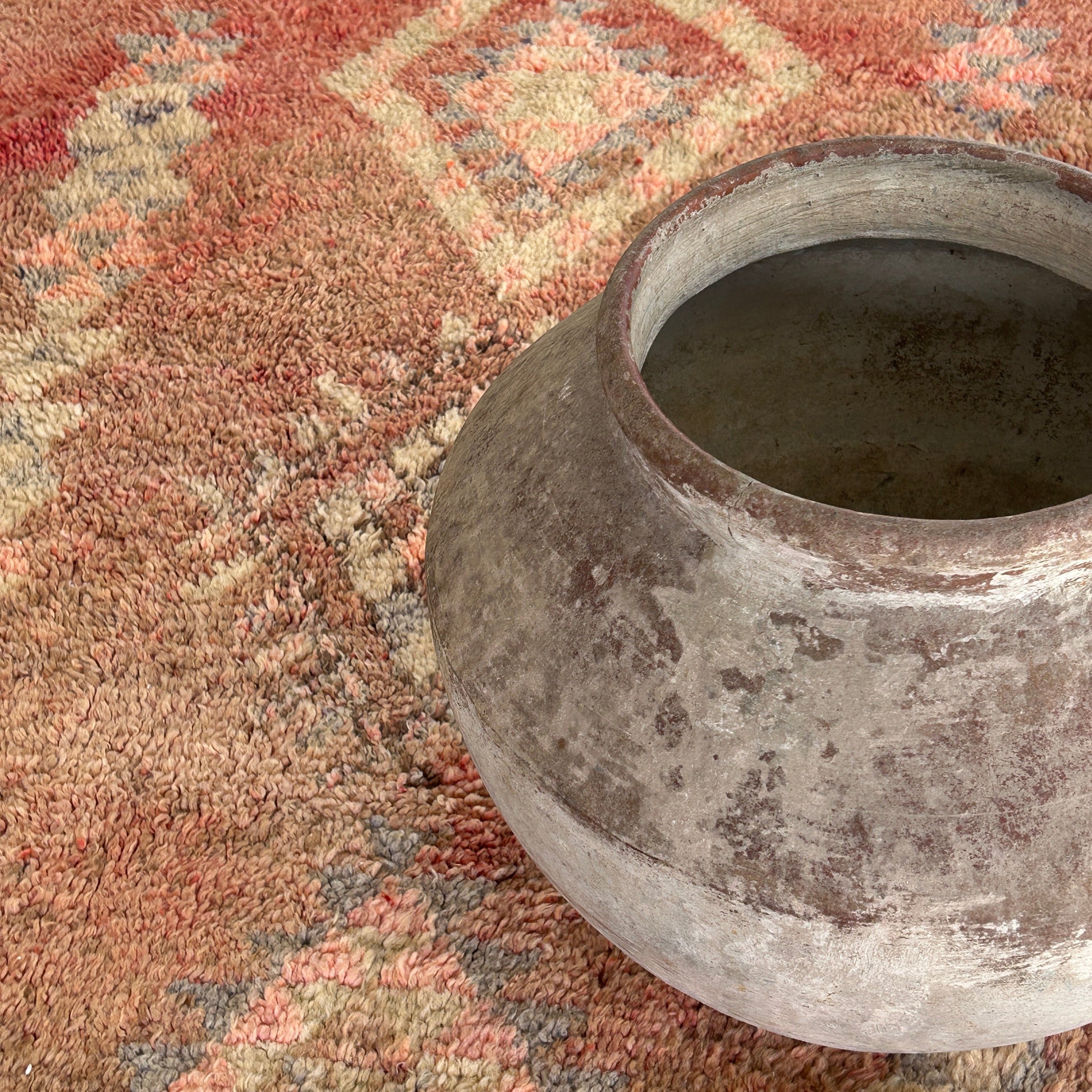Weathered urn on a vintage Moroccan rug.