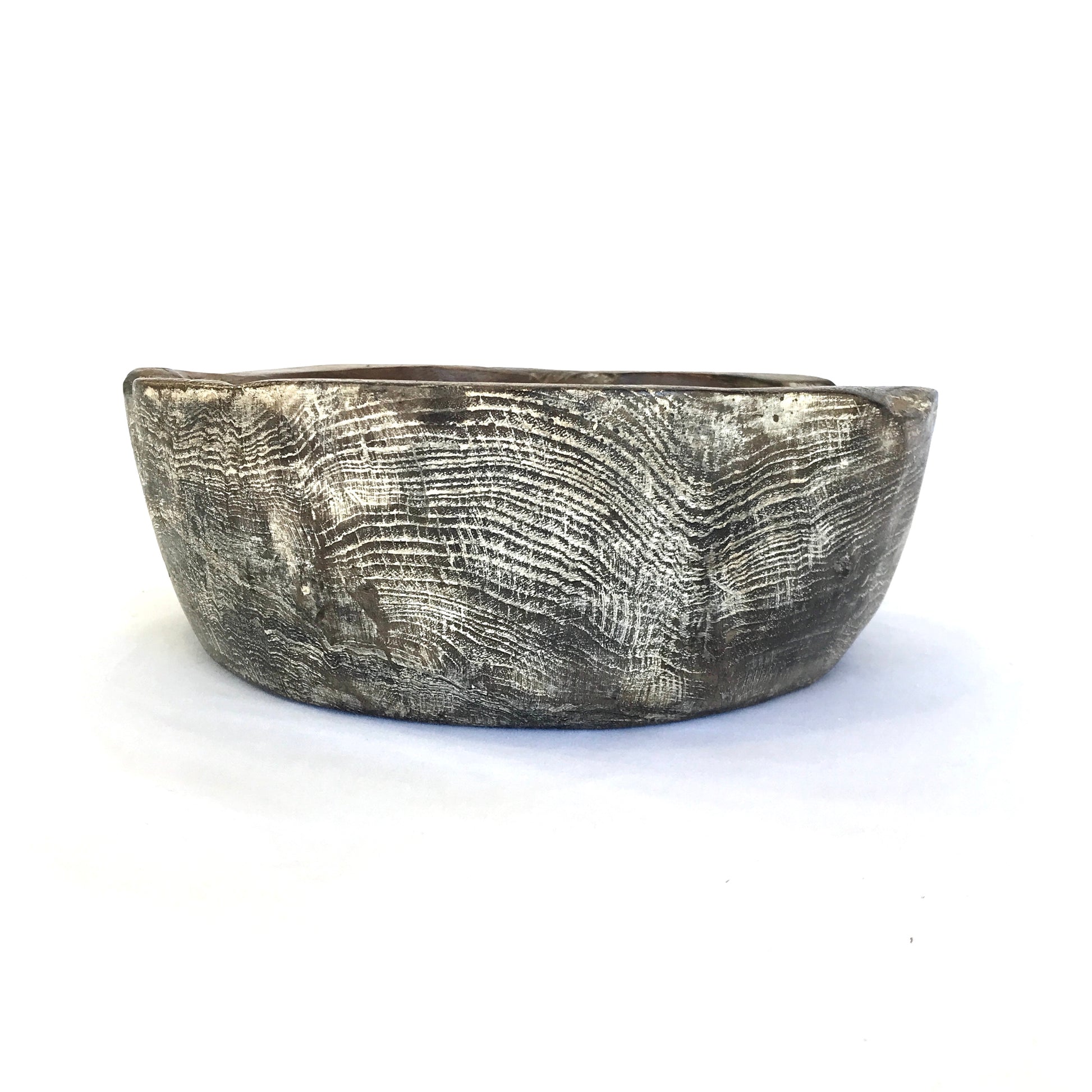 Side profile of a hand carved teak bowl showing the timber grain, against a white background.