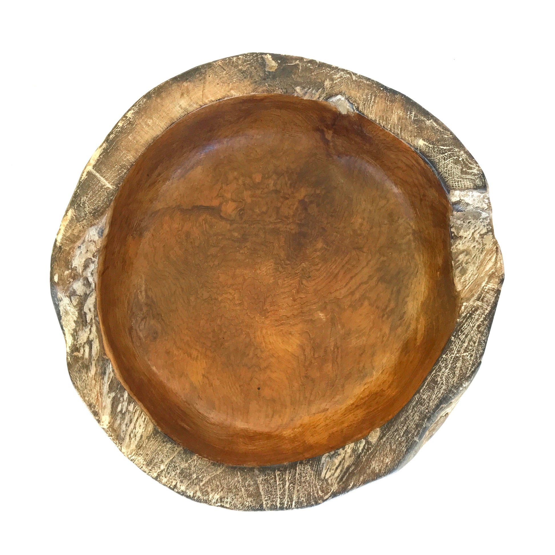 Top down view of a hand carved teak bowl on a white background
